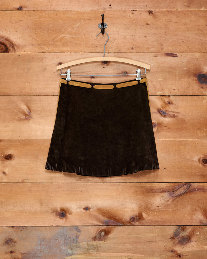 Carson Skirt in dark brown Western suede, featuring a tan cutout waistband and fringed hem, displayed on a wooden hanger. Perfect for bringing rustic flair to a girls’ Western costume.