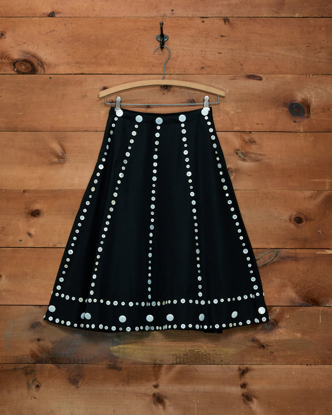 Pearly Royal black A-line skirt with vertical and horizontal rows of white pearl buttons.