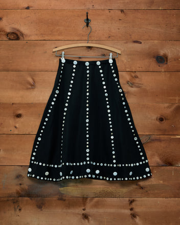Pearly Royal black A-line skirt with vertical and horizontal rows of white buttons.