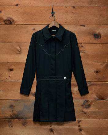 Loving Dress: black wool long-sleeved mini dress with a Western yoke, white contrast stitching, and a pleated skirt.