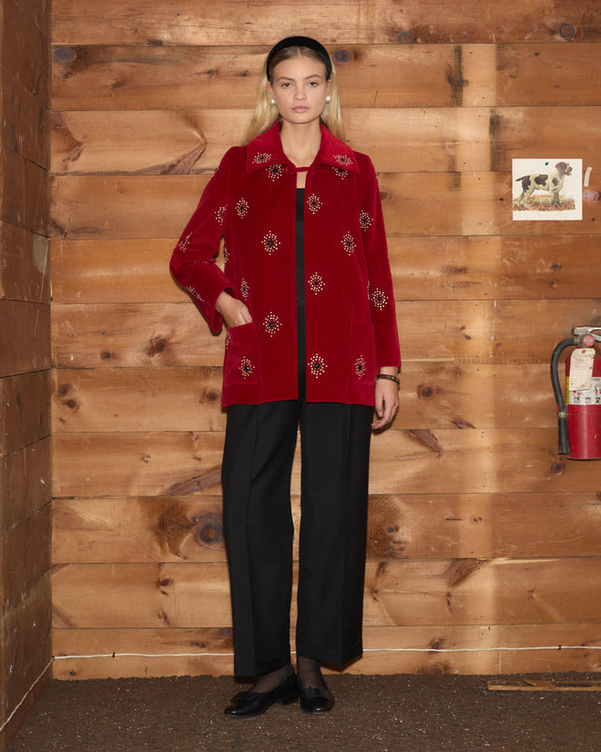 Luminaire Jacket in red velvet with floral pearl and bullion embroidery, worn over a black top and trousers.
