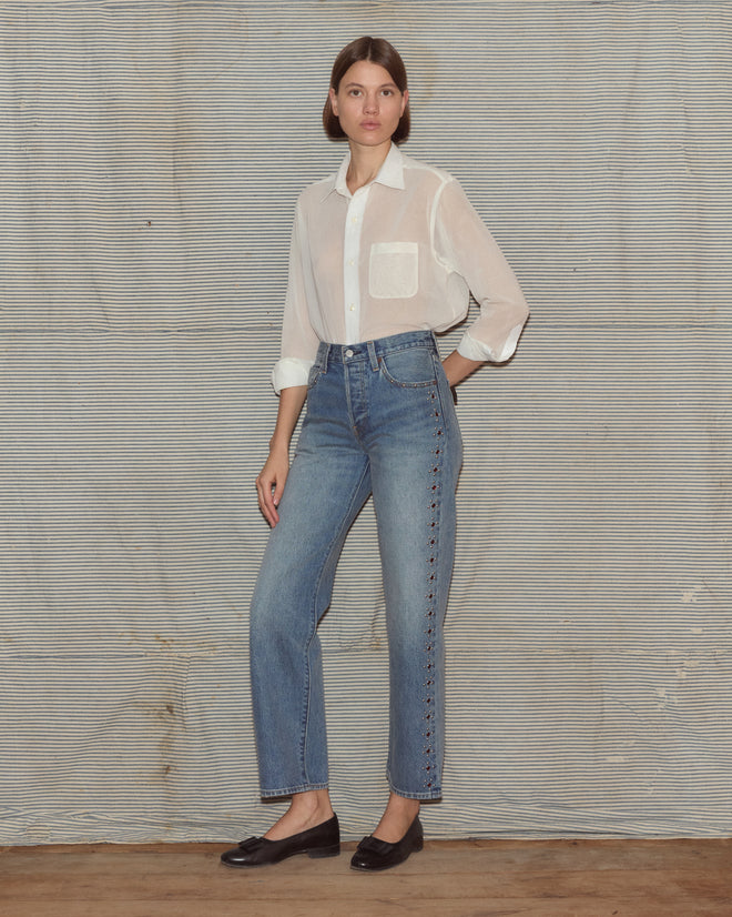 Woman wearing a light blouse and light wash jeans