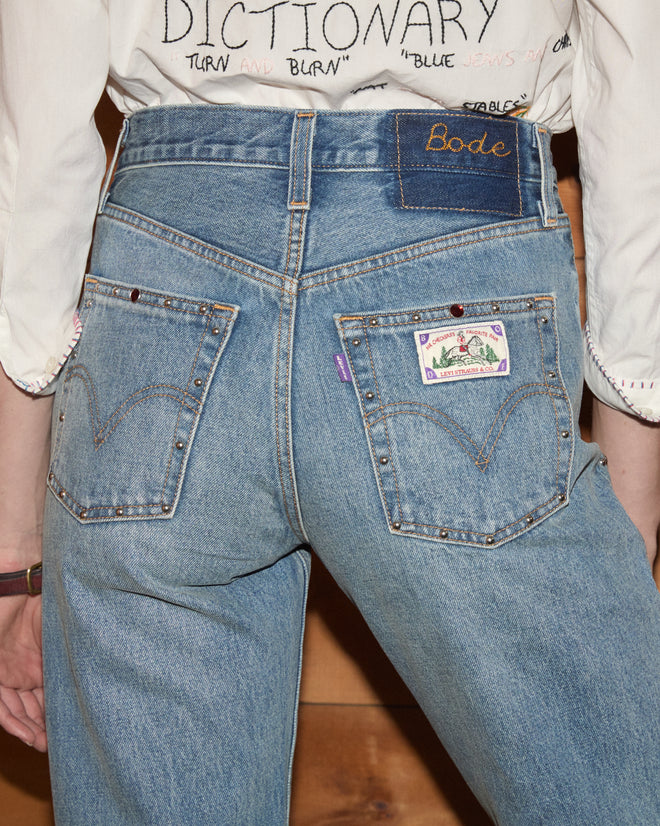 Woman wearing light wash jeans faing backwards