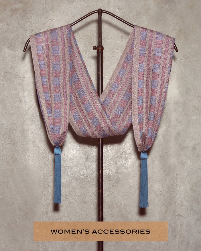 A pink and blue knit scarf draped over a store display stand.
