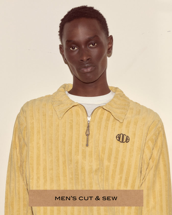 A portrait of a model wearing a yellow/green quarter zip.