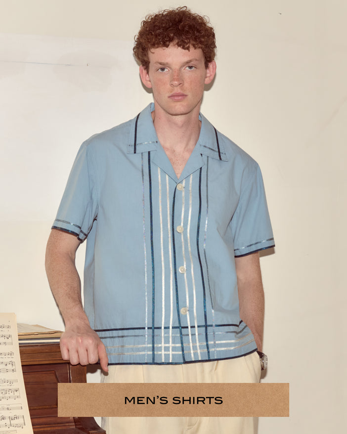 Model wearing a pale blue short sleeve button up shirt with a plaid pattern made of ribbons.